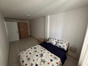 a bedroom with a bed with a comforter and pillows at Deluxe apartament Vatra Dornei in Vatra Dornei