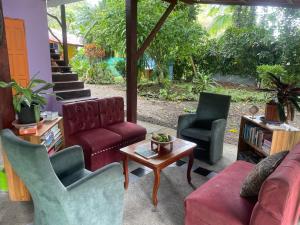 a living room with a couch and two chairs and a table at Colibri Paradise in Cahuita