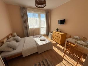 a bedroom with a bed and a table and a window at NIKA Pokoje u Weroniki in Władysławowo
