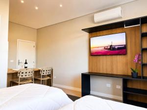 a bedroom with a bed and a dining table at Welkom Woord - Aluguel Flats e Aptos curta temporada - Entrada com senha in Holambra