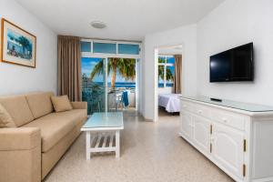 a living room with a couch and a tv at Apartamentos Tamaragua in Playa del Ingles