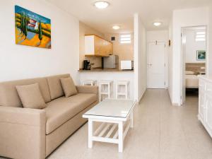 a living room with a couch and a table at Apartamentos Tamaragua in Playa del Ingles