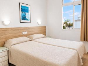 a bedroom with two beds and a window at Apartamentos Tamaragua in Playa del Ingles +25 photos