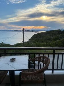 a table and chairs on a balcony with a view of the water at Thanos ,Rooms and Apartments in Ouranoupoli +33 photos
