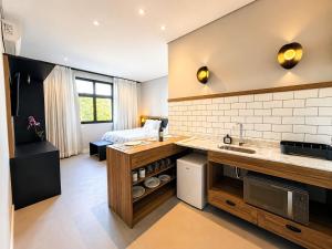 a kitchen with a sink and a living room at Welkom Woord - Aluguel Flats e Aptos curta temporada - Entrada com senha in Holambra
