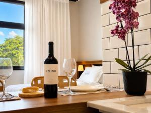 a bottle of wine sitting on a table with glasses at Welkom Woord - Aluguel Flats e Aptos curta temporada - Entrada com senha in Holambra