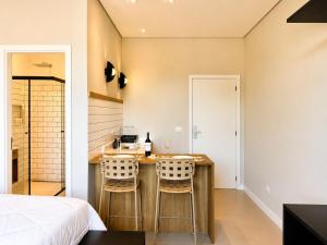 a bedroom with a bed and a desk with two chairs at Welkom Woord - Aluguel Flats e Aptos curta temporada - Entrada com senha in Holambra +12 photos