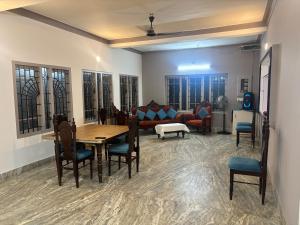 a living room with a table and chairs and a couch at Oceanbliss Villa in Pallipuram