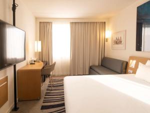 a hotel room with a bed and a desk at Novotel Antwerpen - Ekeren in Antwerp
