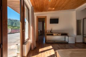 a room with a bed and a tv and a window at Anne's Hotel in Mestia in Mestia