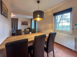 a dining room with a wooden table and chairs at Landhuis Schneifel in Brandscheid