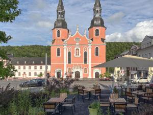 a church with tables and chairs in front of it at Landhuis Schneifel in Brandscheid