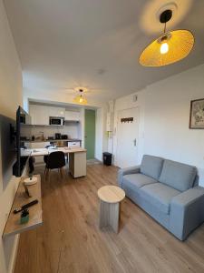 a living room with a couch and a table at Cocon de la gare in Montélimar