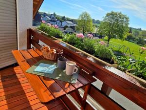 a wooden bench sitting on a balcony with a basket of vegetables at Ferienwohnung Matheaperle mit Infrarotkabine in Nidda