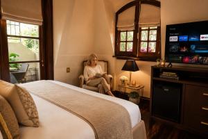 a woman sitting in a chair in a hotel room at Miravida Soho Hotel & Wine Bar in Buenos Aires