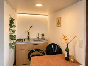 a small kitchen with a table and a sink at ECOHostal Las Hamacas Rincon Del Árbol in Villamaría