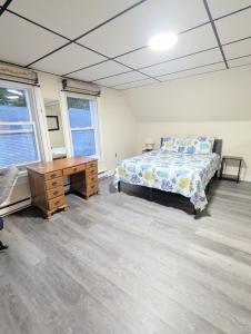 a bedroom with a bed and a desk and windows at 1 central ave in Old Orchard Beach