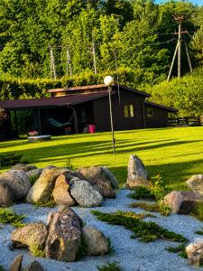 a garden with rocks in front of a house at Argentum Luxury Bungalov in Gąbin