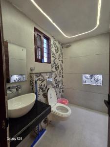 a bathroom with a white toilet and a sink at Eknav Villa in Kharar