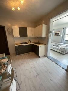 a kitchen with white cabinets and a living room at Casa Estense in Lido degli Estensi