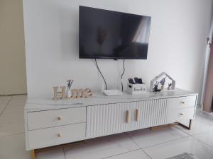 a white dresser with a television on top of it at Sky13 Homestay in Kota Bharu