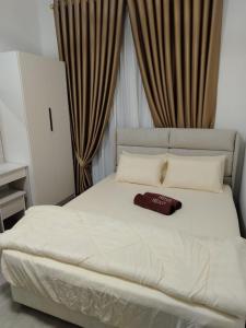 a white bed with a brown hat on top of it at Sky13 Homestay in Kota Bharu