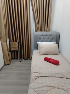 a bed with a red pillow on top of it at Sky13 Homestay in Kota Bharu