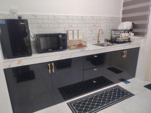 a kitchen with a sink and a microwave at Sky13 Homestay in Kota Bharu