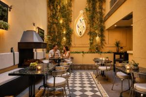 two people sitting at tables in a restaurant at Miravida Soho Hotel & Wine Bar in Buenos Aires