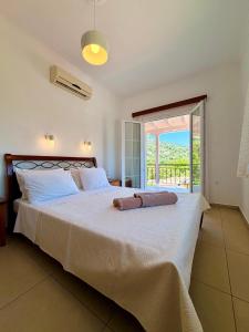 a bedroom with a large white bed with a balcony at Xenia Apartments in Vasiliki +125 photos