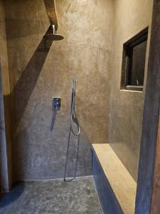 a bathroom with a shower with a hose on the wall at Nkinga River Lodge in Balule Game Reserve +44 photos
