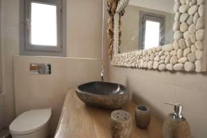 a bathroom with a bowl sink on a wooden counter at Harmony Villa in Karpathos +56 photos