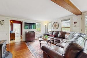 a living room with a leather couch and a table at High Street Retreat in Cavendish