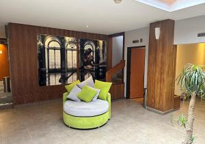 a living room with a green chair and a painting at Hotel El Conde Naucalpan Only Adults in Mexico City