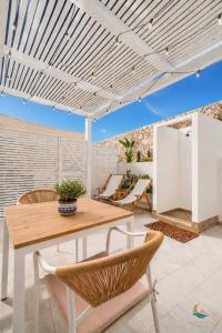 a patio with a wooden table and chairs at Mareluna Luxury Accomodation in Lampedusa