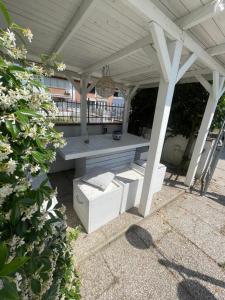 a white pergola with a bench on a patio at Casa Estense in Lido degli Estensi