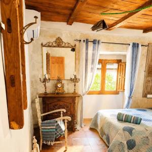 a bedroom with a bed and a mirror and a chair at Casa rural en Buendía -la Galera con 4 dormitorios in Buendía
