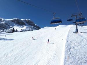 a group of people skiing down a snow covered ski slope at Zattach 57 in Lake Pressegg