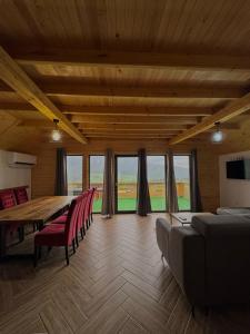 a dining room with a table and chairs and windows at Vlasic Odmor - Villa Vlasicka Bajka in Vlasic