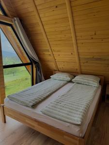 a bed in a room with a large window at Vlasic Odmor - Villa Vlasicka Bajka in Vlasic