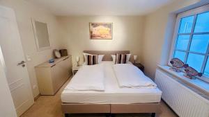 a bedroom with a large white bed with a window at Heefkant Haus Heefkant, HK 04 in Rantum