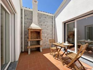 a patio with a table and chairs on a balcony at Casa do Miradouro in São Bartolomeu do Outeiro