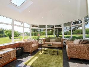 a living room with a lot of windows at Fron-Haul in Llansantffraid-ym-Mechain