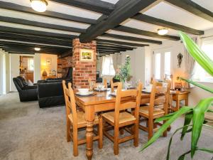 a dining room with a wooden table and chairs at Fron-Haul in Llansantffraid-ym-Mechain