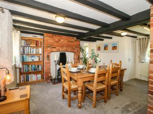 a dining room with a wooden table and chairs at Fron-Haul in Llansantffraid-ym-Mechain