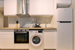 a white kitchen with a washing machine in it at Apartamento Duplex en La Molina in Alp +6 photos