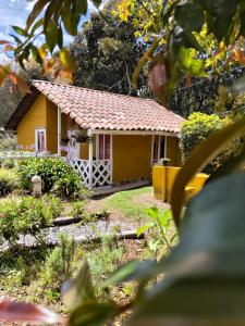 a small yellow house with a red roof at Hospedaje Santaelena -chalets de montaña- in Santa Elena