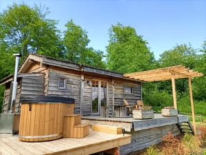 a log cabin with a deck and a pergola at Les Gîtes De Robin'son in Foulcrey