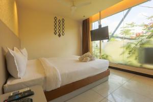 a bedroom with a bed and a window and a desk at Hotel Shrimmaya, Ujjain in Ujjain +73 photos