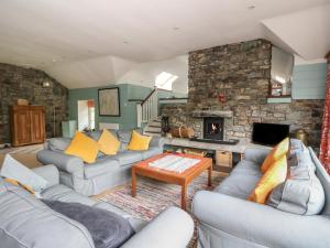 a living room with couches and a stone fireplace at Culearn Mill in Lochearnhead